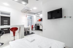 - un salon blanc avec une télévision murale dans l'établissement Black and Red squares apartment, à Lviv