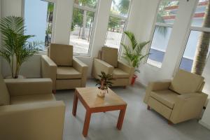 a waiting room with chairs and a table and windows at Scarlet Sails Resort in Koh Rong Island