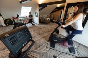 a woman riding a scooter in a gym at Hotel Arok in Strasbourg