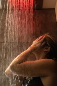 a woman is sitting under a waterfall at Hotel Arok in Strasbourg +44 photos