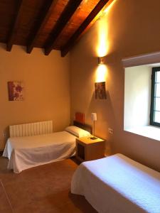 a bedroom with two beds and a window at Casa Rural Fuente la Bolera in Gilbuena