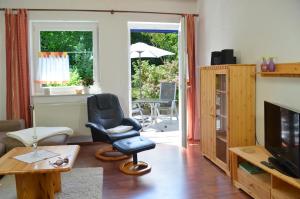un salon avec une chaise et une télévision dans l'établissement Ferienwohnungen Familie Fuss, à Bischofsgrün