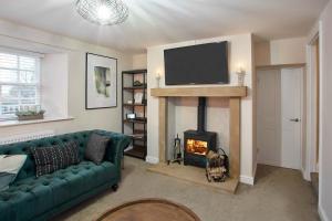 a living room with a green couch and a fireplace at Host & Stay - Middle Farmhouse in Whitby