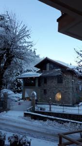 een huis bedekt met sneeuw met een hek ervoor bij Appartamento Limone Piemonte in Limone Piemonte