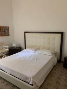 sypialnia z dużym białym łóżkiem z dużym zagłówkiem w obiekcie Matteo's home w mieście Donnalucata