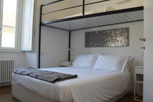 1 dormitorio con 1 cama blanca grande y cabecero negro en Palazzo della Torre Elegant Apartment in Como, en Como