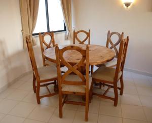 einen Holztisch und Stühle mit einem Tisch und einem Fenster in der Unterkunft Casa Julio in Carvoeiro