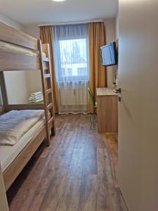 a room with a bunk bed and a television at Hotel Cristal in Nürnberg