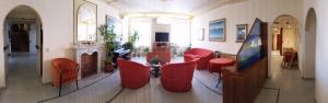 a living room with red chairs and a fireplace at Hotel Badano sul Mare in Alassio +41 photos