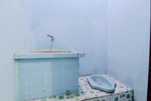 a bathroom with a blue toilet on a tiled floor at Losmen Parikesit in Bantul