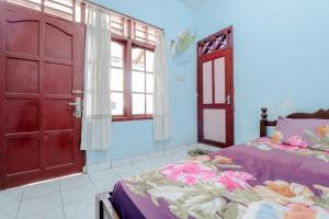 a bedroom with a bed and an open door at Losmen Parikesit in Bantul