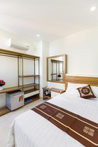 ein Schlafzimmer mit einem großen Bett und einem Spiegel in der Unterkunft Moschino HT in Nha Trang