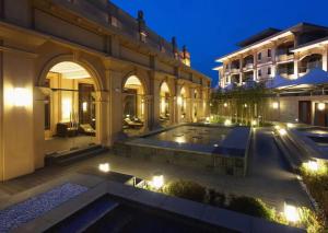 a mansion with a swimming pool at night at Wyndham Grand Tianjin Jingjin City in Tianjin