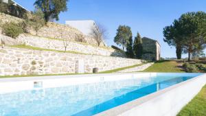 einen Pool vor einer Steinmauer in der Unterkunft Douro Palace Hotel Resort & SPA in Baião