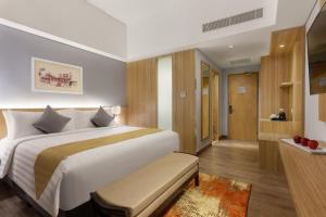 um quarto com uma cama grande e um banheiro em Aston Gresik Hotel & Conference Center em Gresik