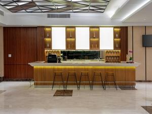 Aston Gresik Hotel & Conference Center في Gresik: لوبى مع بار مع المقاعد