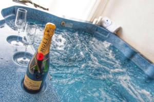 una bottiglia di champagne in una vasca con bicchieri da vino di Ludwig Boutique Hotel & Spa a Bolsena
