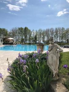 a statue in a garden in front of a pool at Ludwig Boutique Hotel & Spa in Bolsena