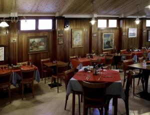 a restaurant with wooden walls and tables and chairs at Hotel Signorini in Castiglioncello