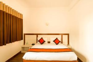 a bedroom with a bed with orange and white sheets at Airport Hotel in New Delhi