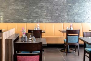 une salle à manger avec des tables et des chaises dans un restaurant dans l'établissement Altstadthotel Guesthouse Die Galerie, à Ingolstadt
