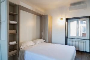 - une chambre avec un lit blanc et une fenêtre dans l'établissement Sapore di Sale by Wonderful Italy, à Gênes