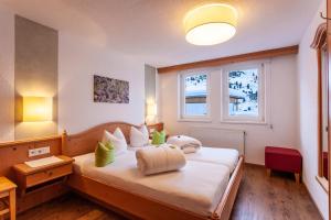 a bedroom with a large white bed with a window at Haus Aktiv in Obergurgl