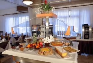 uma mesa com muitos tipos diferentes de alimentos sobre ele em Club Hotel Costaverde em Andalo