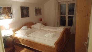 een slaapkamer met 2 bedden met witte lakens en een raam bij Ferientraum Kobellstrasse in Rottach-Egern