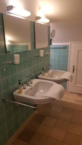 La salle de bains est pourvue d'un lavabo, d'un miroir et d'une baignoire. dans l'établissement Ferientraum Kobellstrasse, à Rottach-Egern