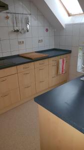 een keuken met houten kasten en een zwart aanrecht bij Ferienwohnung am Sandwater in Ihlow