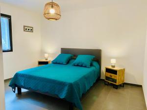 1 dormitorio con 1 cama con sábanas azules y 2 mesitas de noche en Fronte di Mare 2 chambres vue mer - 1 en Propriano