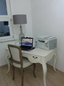 a desk with a computer and a printer and a laptop at ANTICO CORTILE Favignana in Favignana