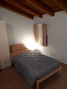 una camera con un letto in una stanza con una finestra di Agriturismo iL CASONE a Zoppola