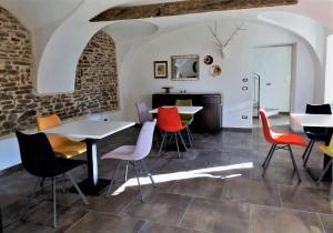 a room with tables and chairs and a fireplace at Cascina Malinverni in Rocchetta Palafea
