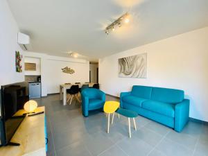 sala de estar con sofá azul y mesa en Fronte di Mare 2 chambres vue mer - 1 en Propriano