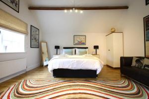 a bedroom with a large bed and a rug at Old Croft Stables in Quarndon