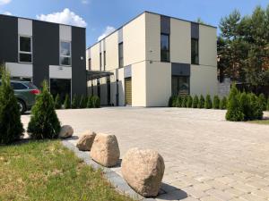 a building with rocks in front of a driveway at Poilsio apartamentai "Jolita" in Druskininkai