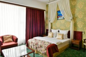 een hotelkamer met een bed en een stoel bij Park Hotel Stavropol in Stavropol