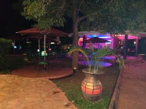 a restaurant with tables and umbrellas at night at Nile Village Hotel & Spa in Jinja