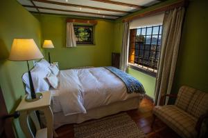 a bedroom with a bed and a chair and a window at Casa en Llao Llao con vista al lago y campo de golf in San Carlos de Bariloche