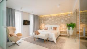 a bedroom with a white bed and a chair at Villa Marina Hvar in Hvar