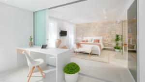 Dieses weiße Zimmer verfügt über einen Schreibtisch und ein Schlafzimmer. in der Unterkunft Villa Gariful in Hvar