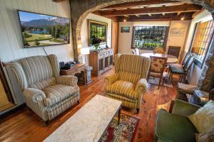 sala de estar con 2 sillas y mesa en Casa en Llao Llao con vista al lago y campo de golf en San Carlos de Bariloche