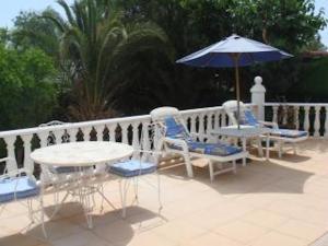 taras ze stołem, krzesłami i parasolem w obiekcie Private Villa with Private Pool Barrio de la Fuensanta w mieście Torre del Rame