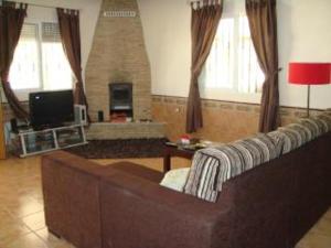 salon z kanapą i kominkiem w obiekcie Private Villa with Private Pool Barrio de la Fuensanta w mieście Torre del Rame