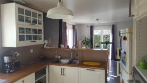 uma cozinha com armários brancos e um lavatório em 2 vraies chambres privées au calme dans villa de campagne plain-pied 105m2 avec piscine à Montfaucon em Montfaucon