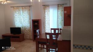 een woonkamer met een tafel en stoelen en een televisie bij Apartamentos Manuel Martin in Nerja