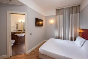 ローマにあるベストウエスタン ホテル アストリドのベッドルーム1室(ベッド1台付)、バスルーム(シンク付)