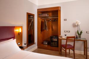 um quarto com uma cama, uma secretária e uma cadeira em Best Western Hotel Astrid em Roma